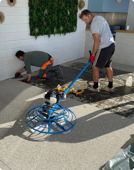 pose de sol en moquette de pierre extérieures avec un artisan qui utilise un helicoptere pour lisser le sol à Estancarbon près de Saint-Gaudens en Haute-Garonne 31